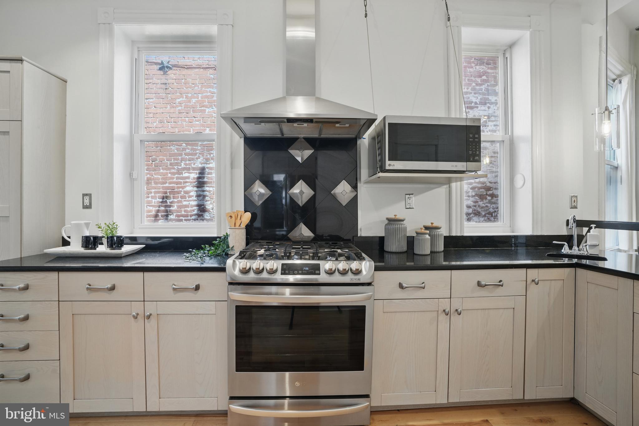 136 R Street Northeast Washington, DC 20002 - Photo 16 of 36 a kitchen with granite countertop white cabinets and appliances