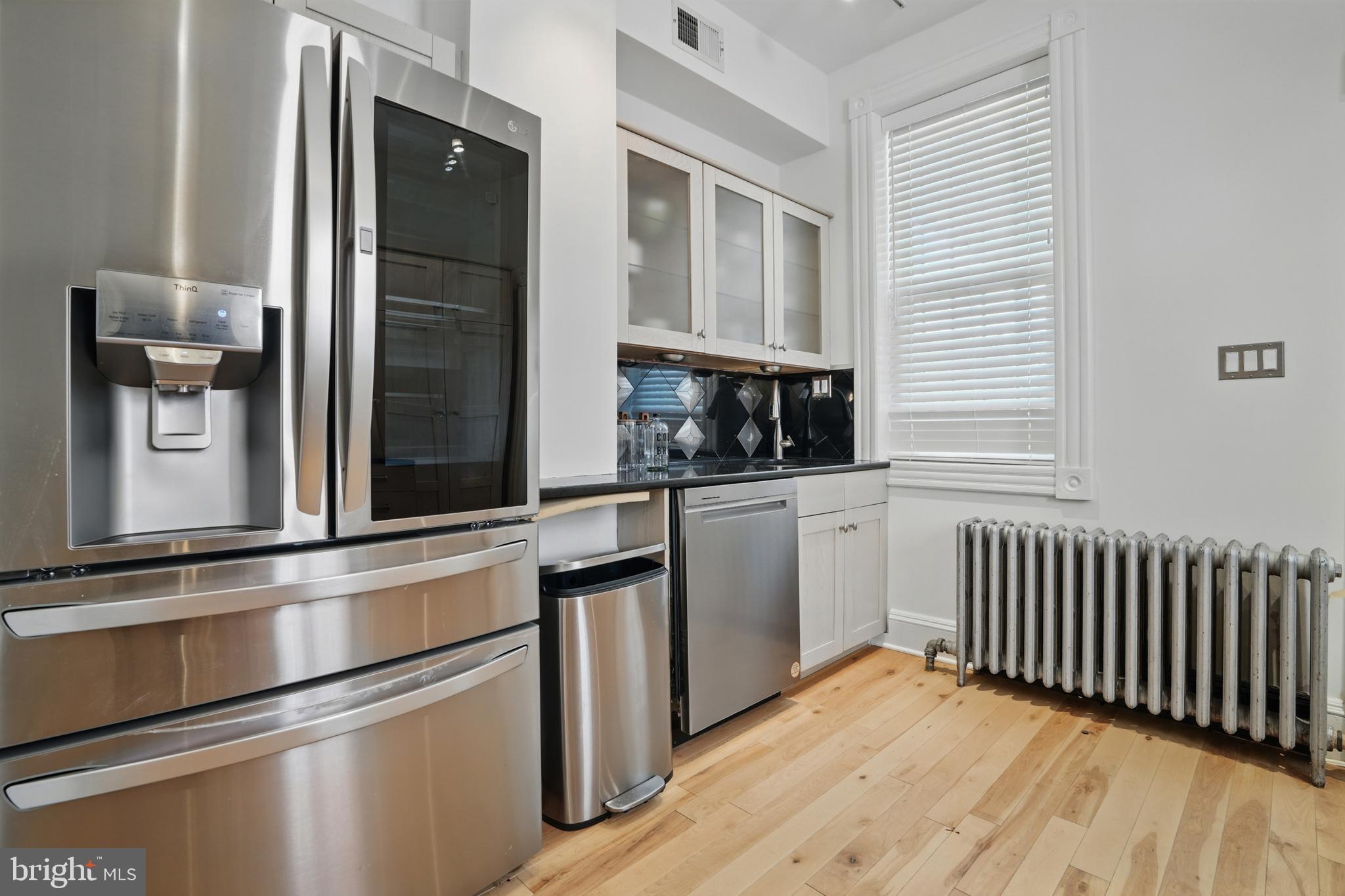 136 R Street Northeast Washington, DC 20002 - Photo 18 of 36 a kitchen with white cabinets and black appliances