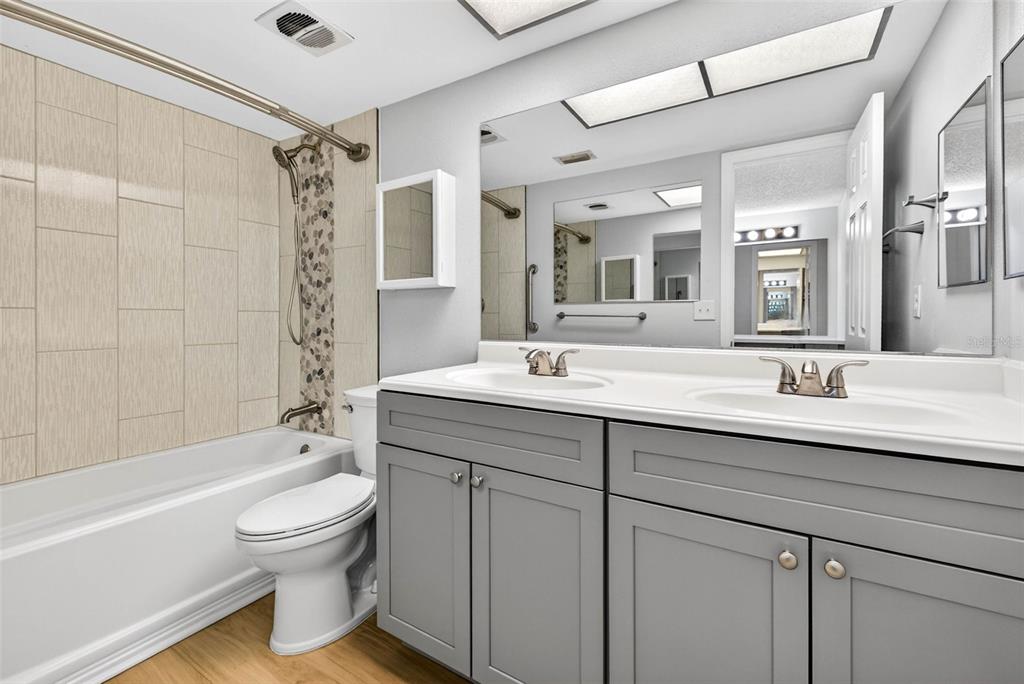 5197 Silent Loop, Unit 124 New Port Richey, FL 34652 - Photo 35 of 55 a bathroom with a double vanity sink toilet mirror and shower