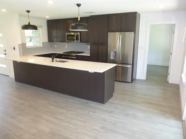 a kitchen with stainless steel appliances granite countertop a refrigerator and a stove