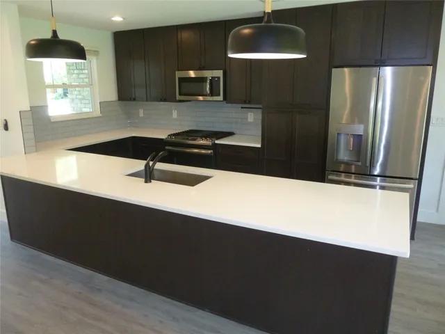 a kitchen with a sink a refrigerator and stove