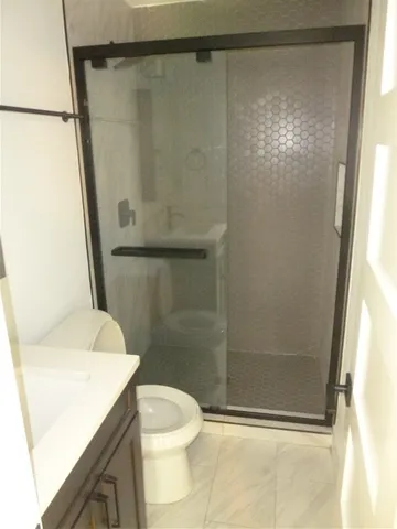 a bathroom with a shower a toilet and a sink