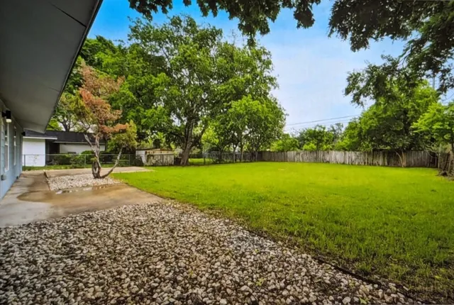 a view of a house with a yard and tree s