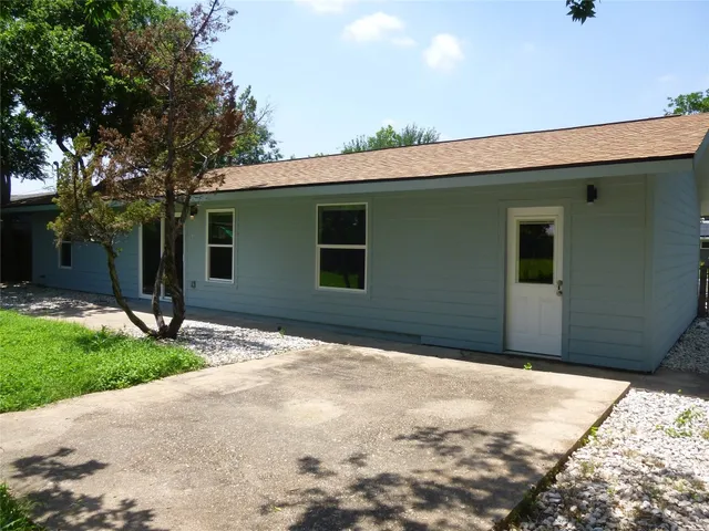 a backyard of a house with garage and garden