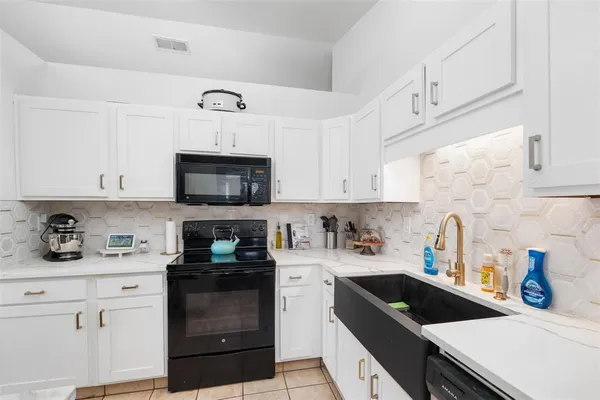 a kitchen with a sink a stove and cabinets