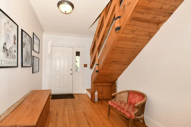 a view of front door with wooden floor and stairs