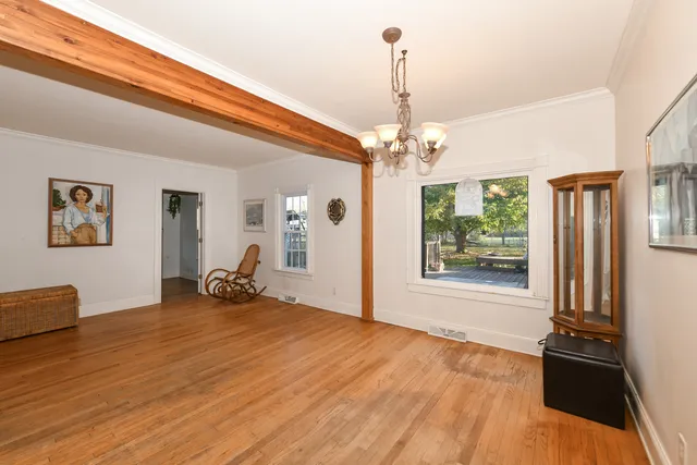 a view of a livingroom with a furniture wooden floor and chandelier