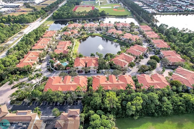 an aerial view of residential houses with outdoor space and lake view