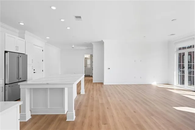 wooden floor in an empty room with a kitchen