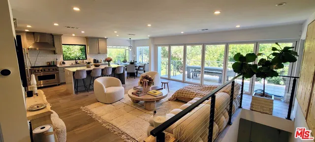 a view of a dining room with furniture a flat screen tv and floor to ceiling window