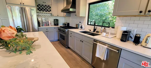 a kitchen with stainless steel appliances a sink stove and cabinets