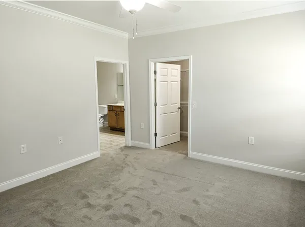 an empty room with closet and a chandelier fan