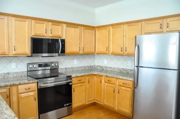 a kitchen with stainless steel appliances granite countertop a refrigerator stove top oven a sink and dishwasher