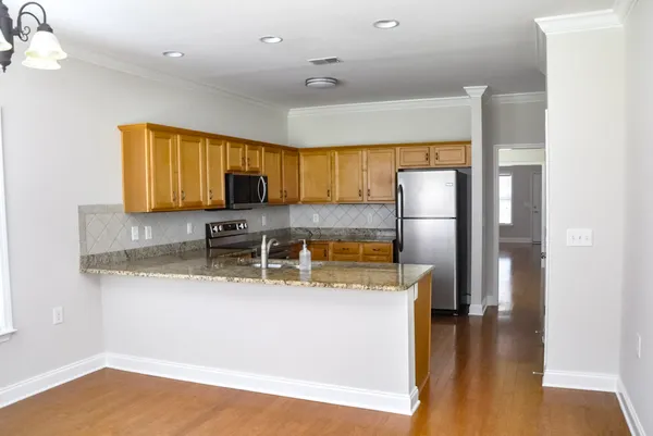 a kitchen with stainless steel appliances granite countertop a refrigerator sink stove and microwave
