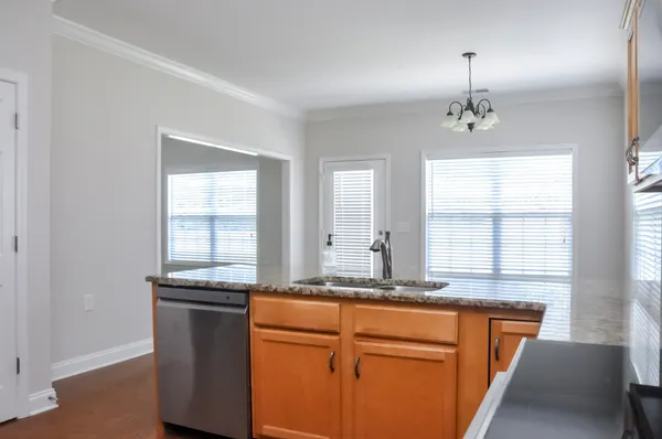 a kitchen with granite countertop a sink and a refrigerator