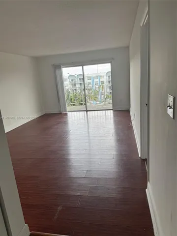 a view of a room with wooden floor and window