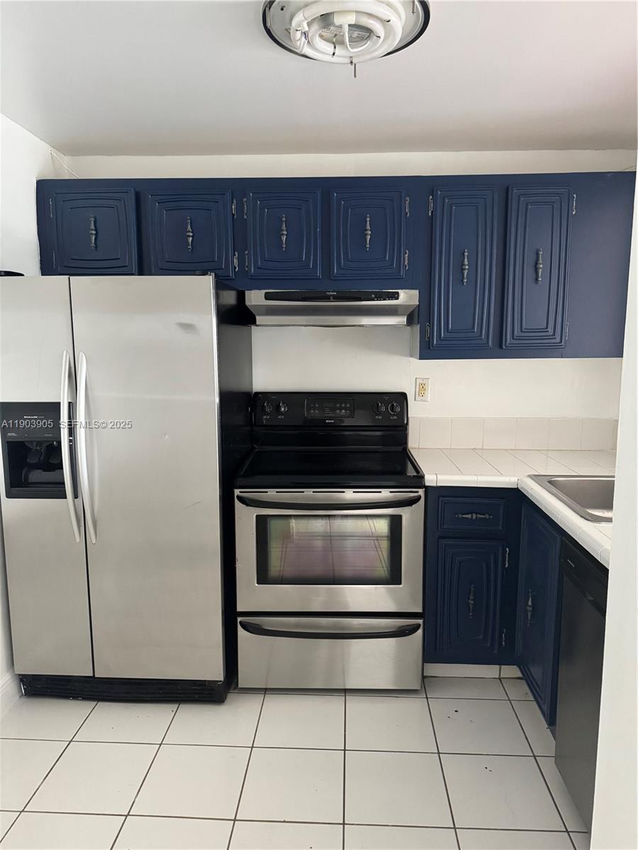 496 Northwest 165th Street, Unit D614 Miami, FL 33169 - Photo 8 of 10 a kitchen with granite countertop a stove a microwave and a refrigerator