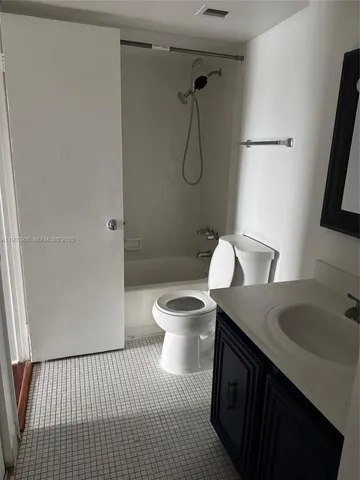 a bathroom with a granite countertop sink toilet a mirror and shower