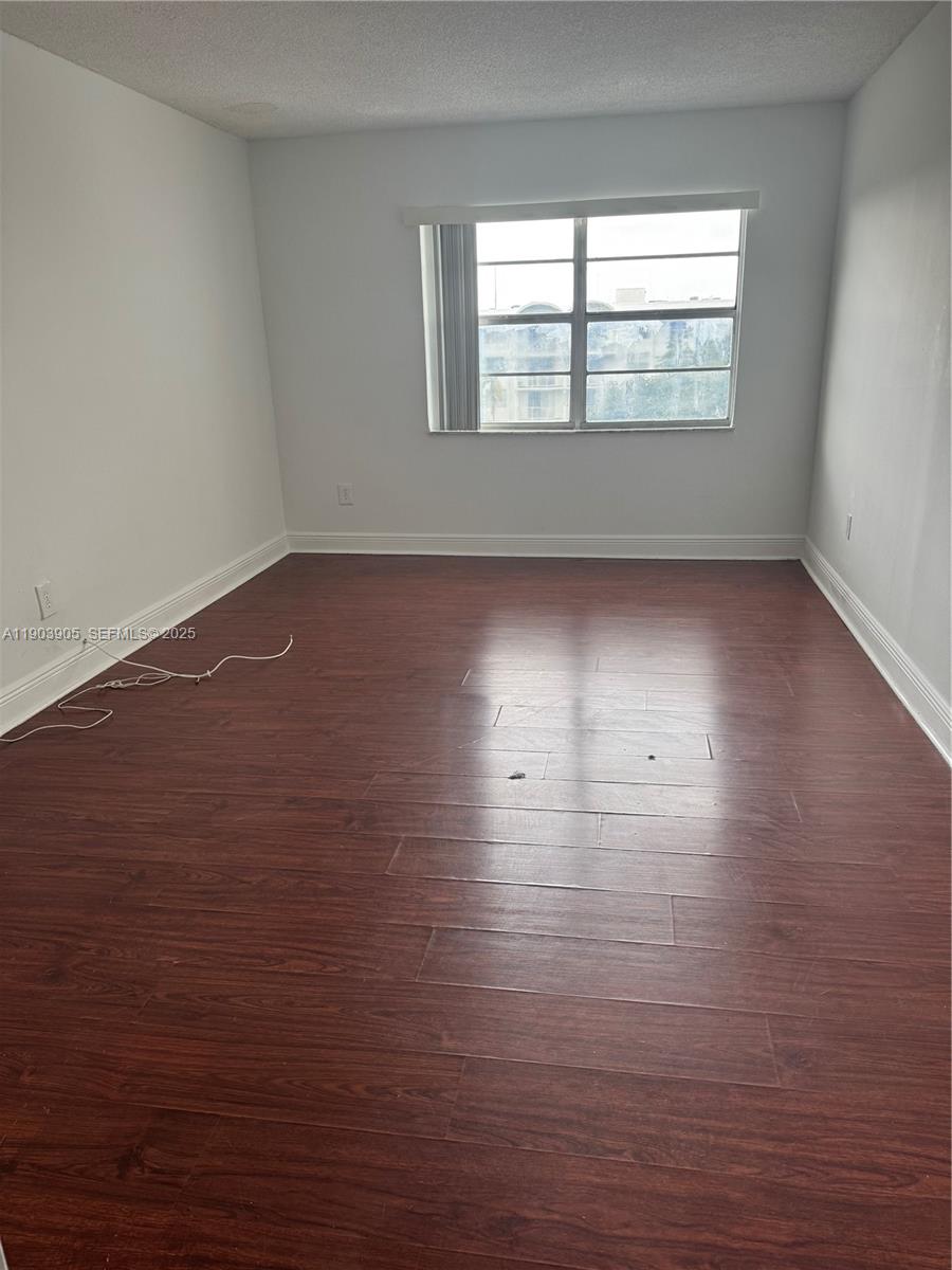 496 Northwest 165th Street, Unit D614 Miami, FL 33169 - Photo 10 of 10 wooden floor in an empty room with a window