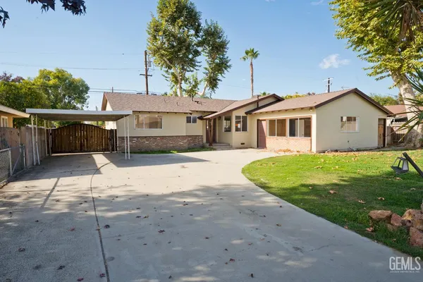 a view of a white house with a big yard and potted plants