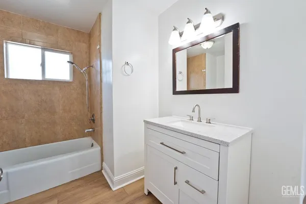 a bathroom with a sink vanity tub and a mirror