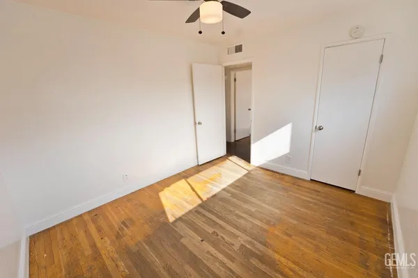 a view of empty room with wooden floor