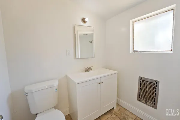 a bathroom with a toilet a sink and mirror