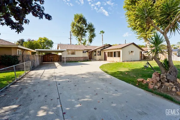 a front view of a house with a yard and potted plants