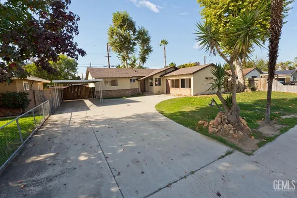 a front view of a house with a garden and trees