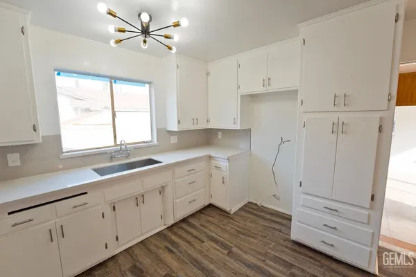 a kitchen with white cabinets and window