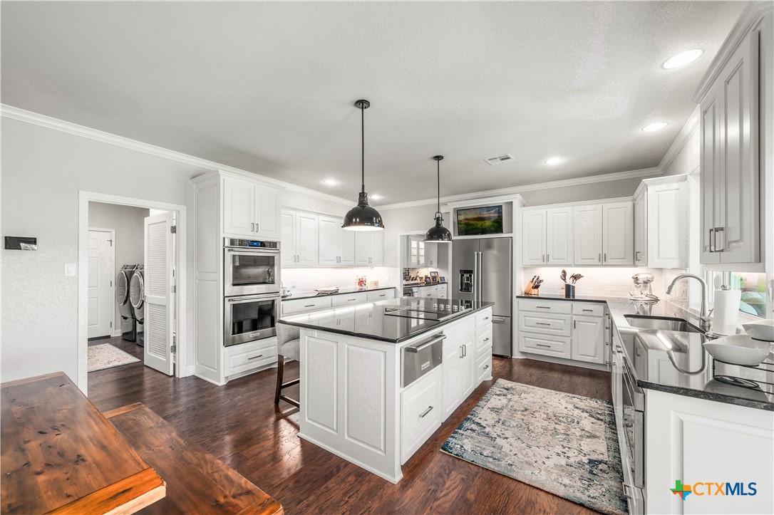617 Bluebonnet Lane Temple, TX 76502 - Photo 12 of 48 a kitchen with stainless steel appliances kitchen island granite countertop a stove and a sink