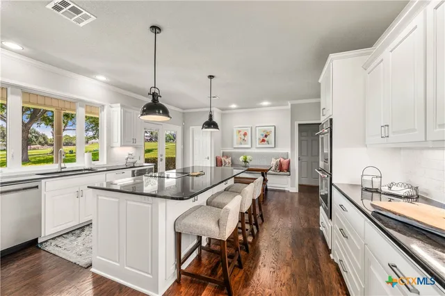 a kitchen with granite countertop white cabinets and white appliances