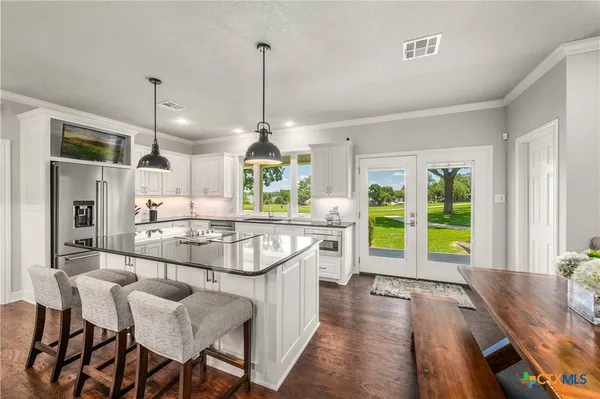 a kitchen with granite countertop white cabinets and white appliances