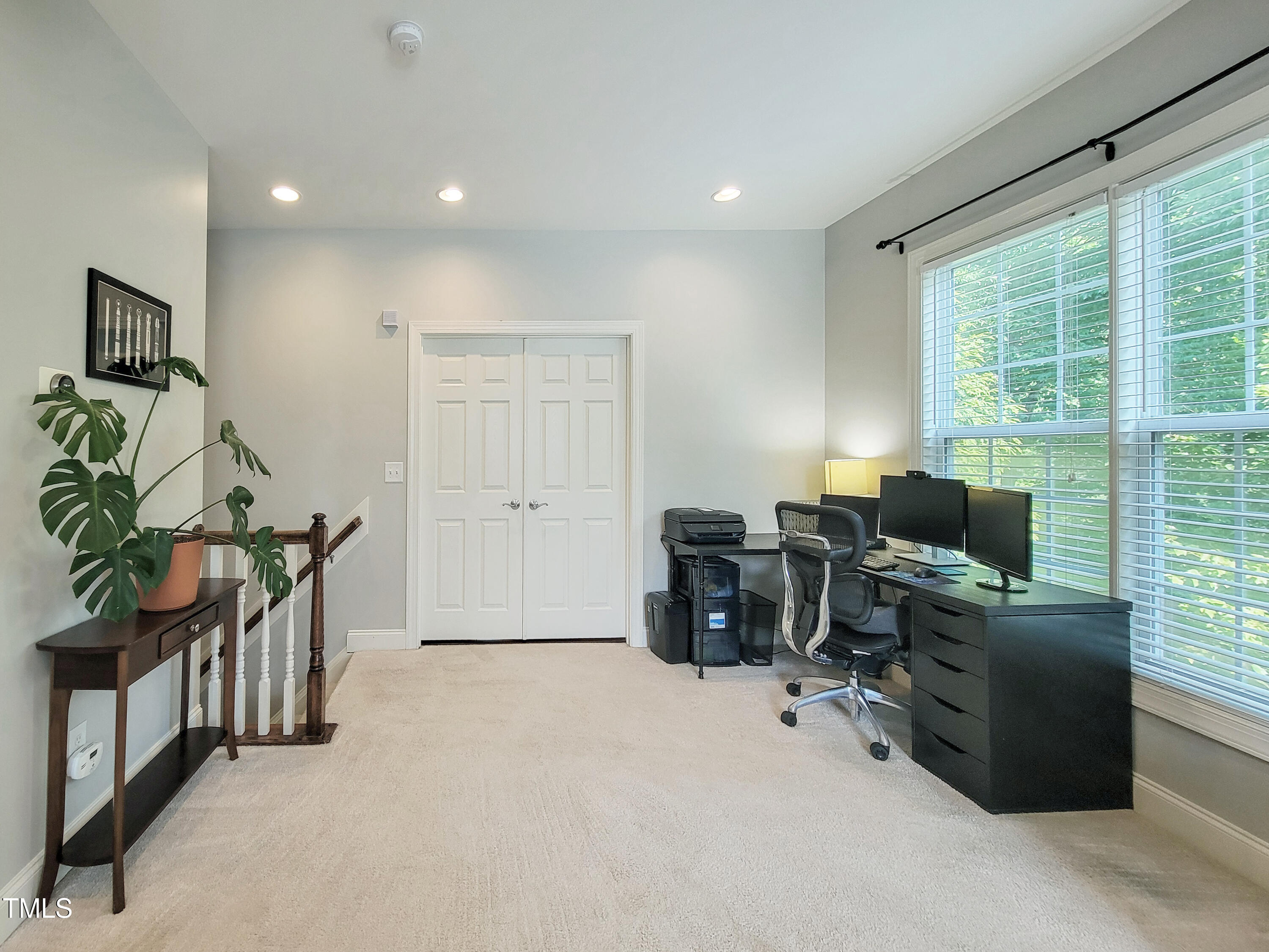 7502 Hedfield Way Durham, NC 27713 - Photo 15 of 28 a view of workspace with a computer on the desk chair couches and a flat tv screen
