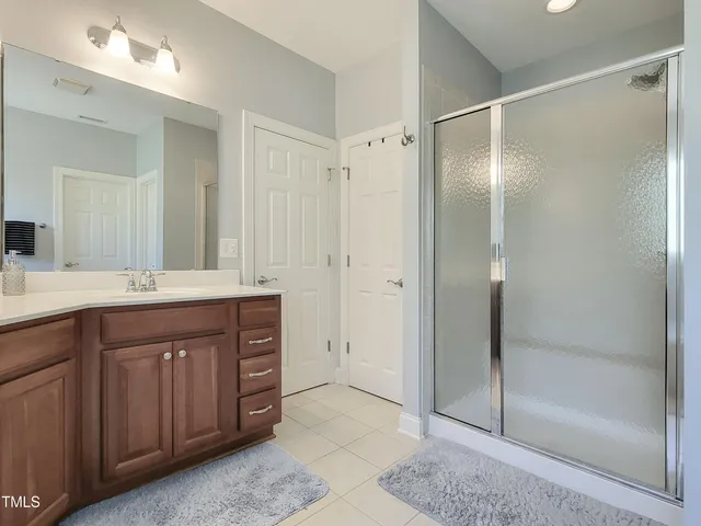 a bathroom with a double vanity sink mirror and shower