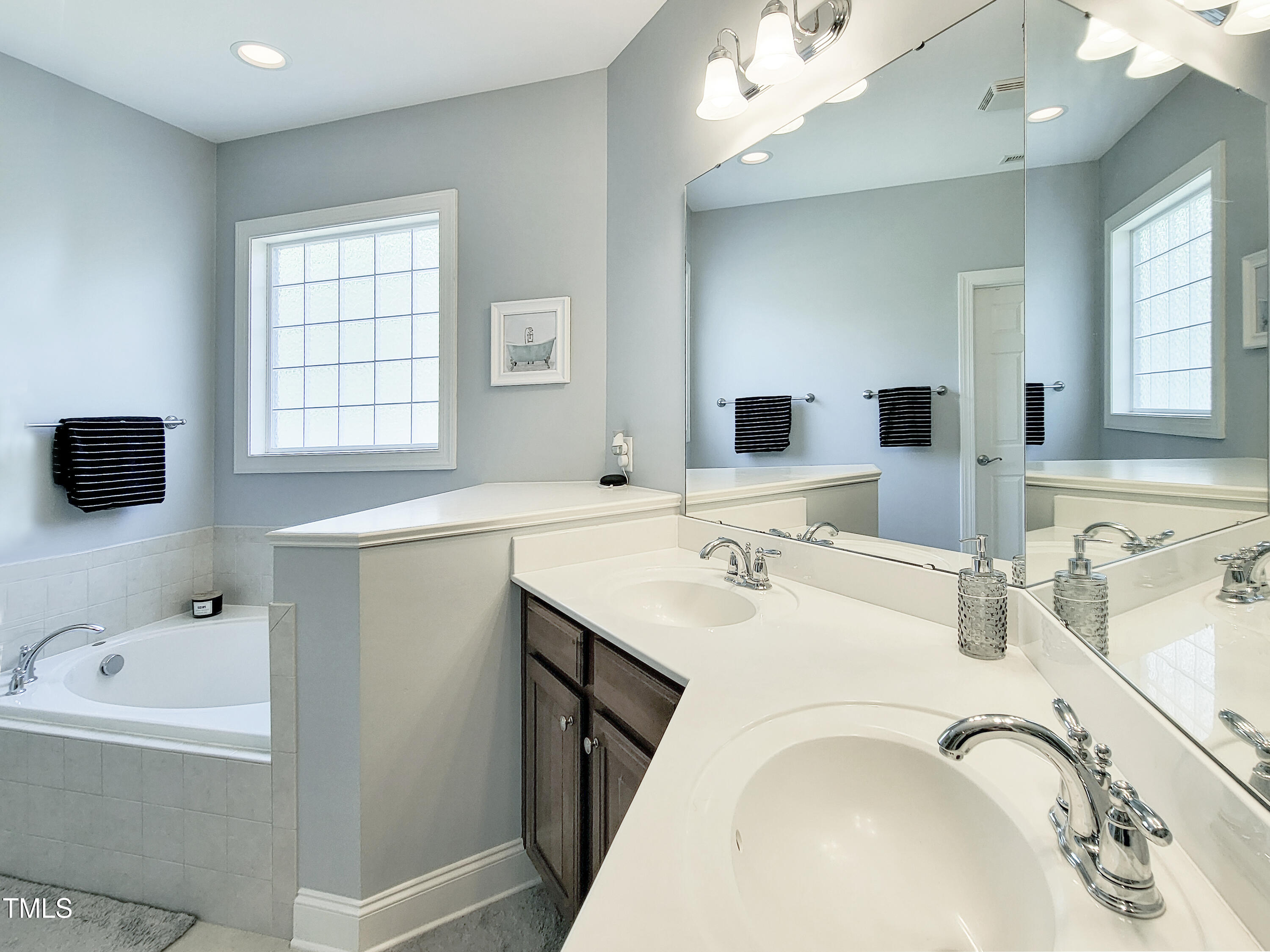 7502 Hedfield Way Durham, NC 27713 - Photo 21 of 28 a bathroom with a tub sink and mirror
