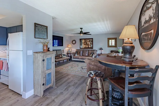 a living room with furniture a desk and kitchen view