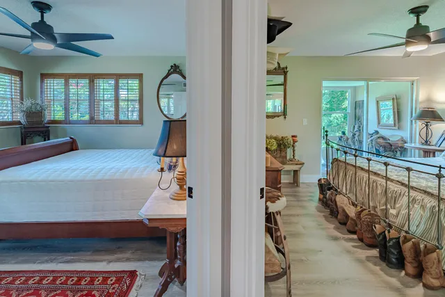 a room with chandelier fan and windows