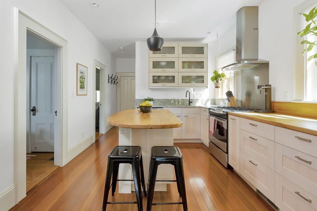 9 Joseph Street, Unit 1 Somerville, MA 02143 - Photo 4 of 17 a kitchen with a table chairs sink and cabinets