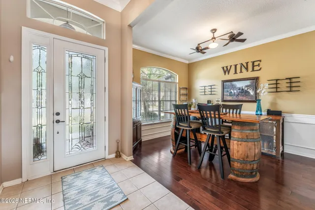 a living room with furniture kitchen view and a chandelier