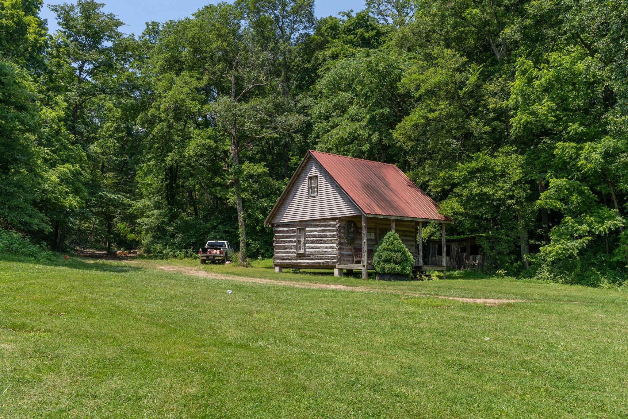 2895 South Possum Hollow Road Nunnelly, TN 37137 - Photo 16 of 25 a backyard of a house with plants and large tree