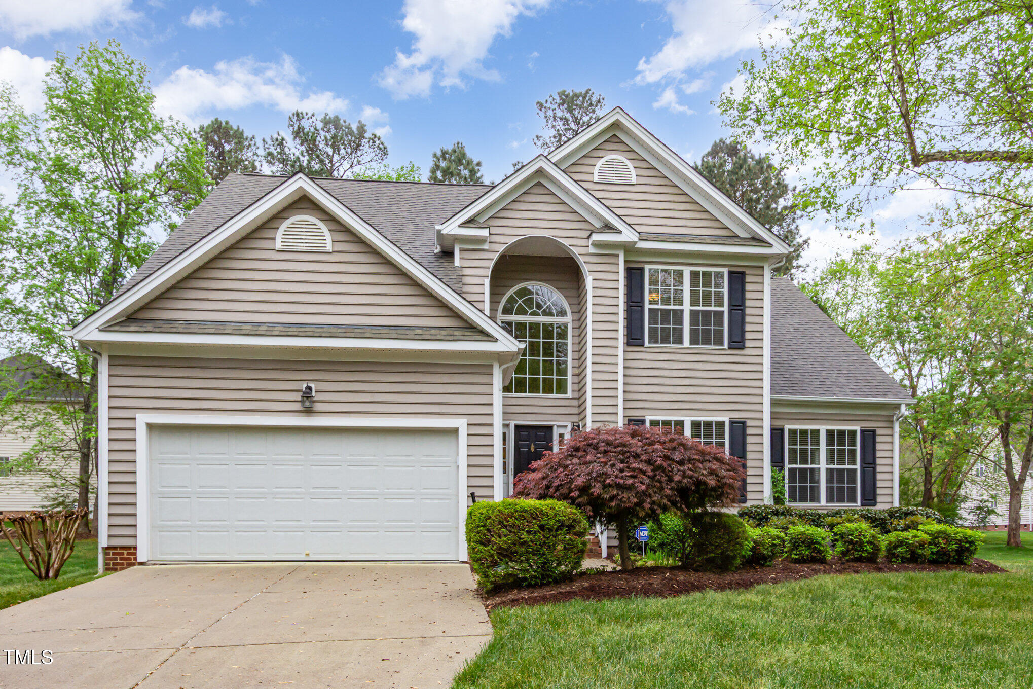 a view of a white house next to a yard