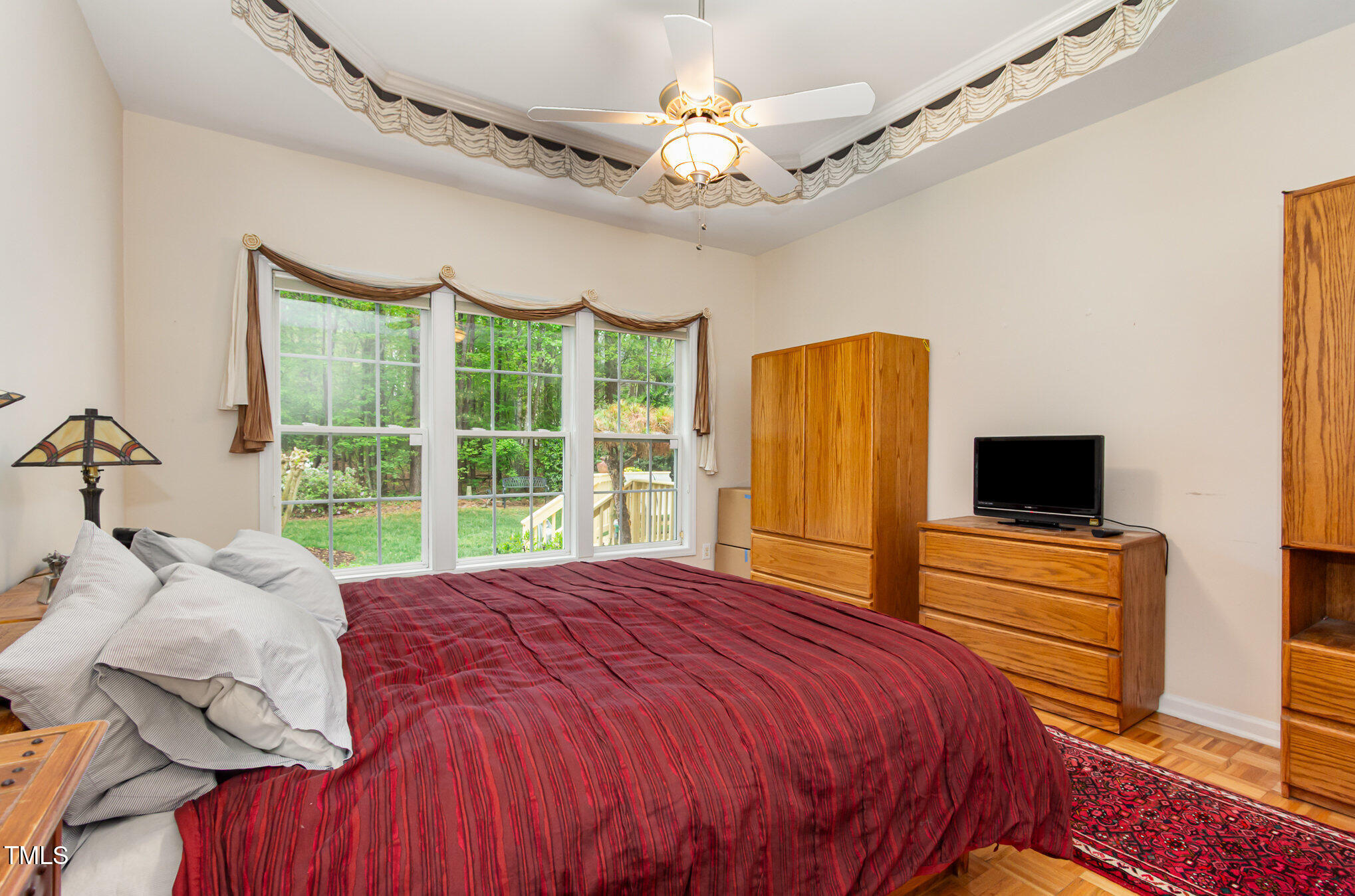 401 Stinhurst Drive Durham, NC 27713 - Photo 17 of 39 a bedroom with a bed and a flat tv screen on dresser