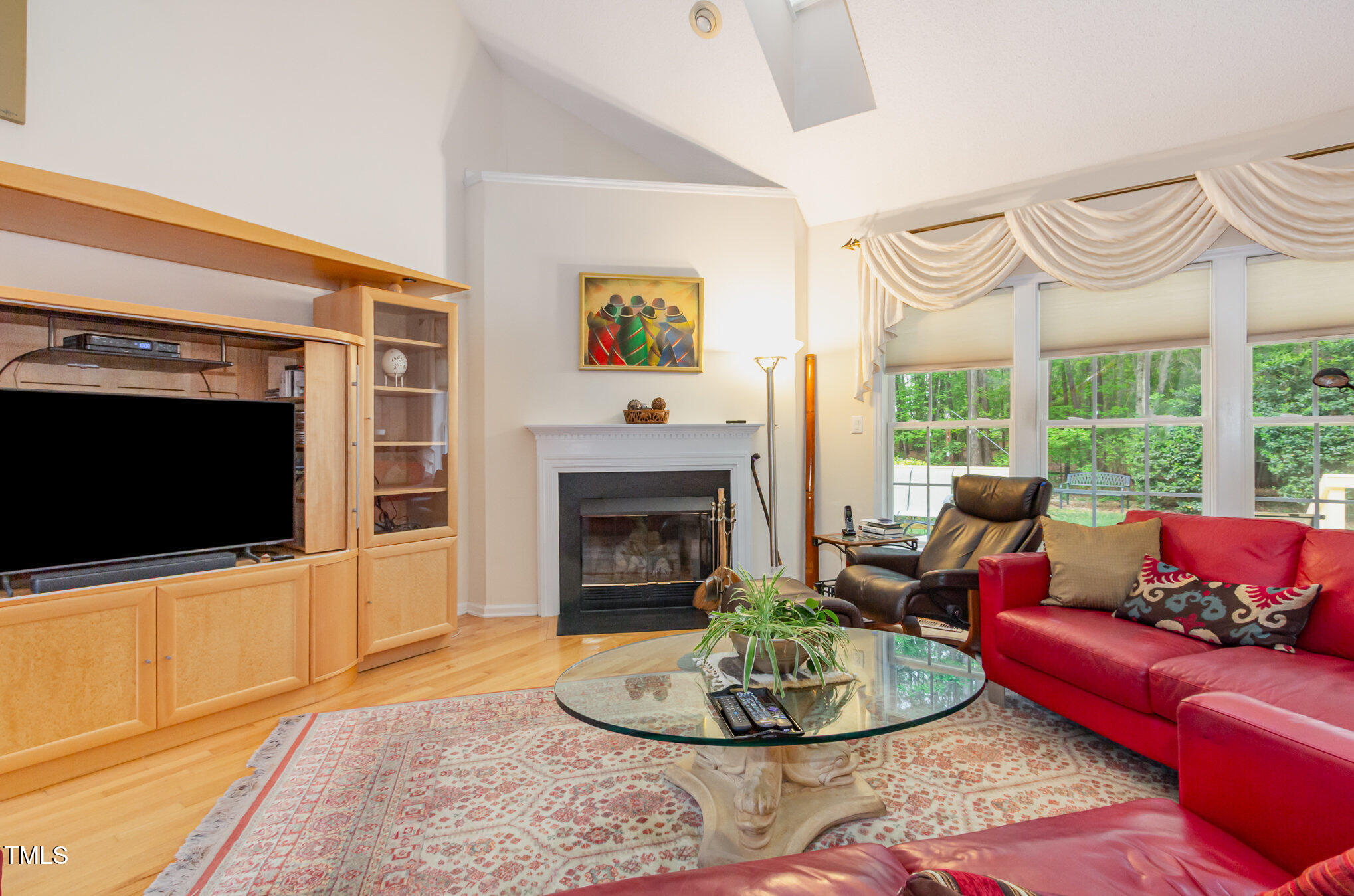 401 Stinhurst Drive Durham, NC 27713 - Photo 4 of 39 a living room with furniture a flat screen tv and a fireplace