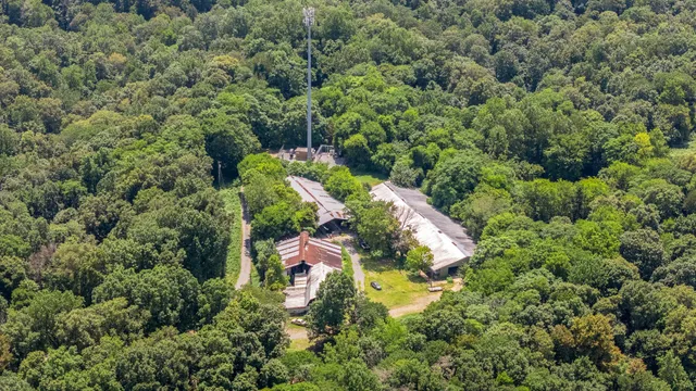 an aerial view of a house with a yard and outdoor seating