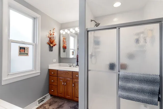 a bathroom with a shower sink and mirror
