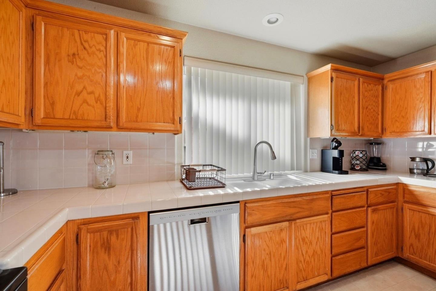 3882 Pintail Court Merced, CA 95340 - Photo 8 of 21 a kitchen with stainless steel appliances granite countertop wooden cabinets a sink and a dishwasher