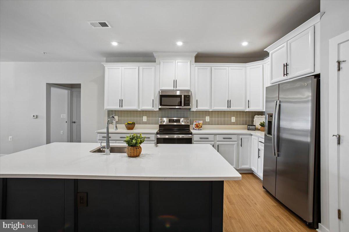 1669 Bandit Loop, Unit 105A Reston, VA 20190 - Photo 11 of 58 Custom tile backsplash, undercabinet lighting