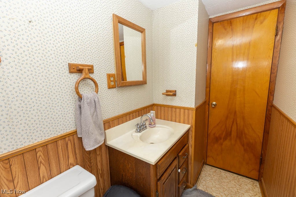 1085 Novak Road Grafton, OH 44044 - Photo 29 of 41 Half bath featuring a wainscoted wall, wallpapered walls, vanity, and wooden walls