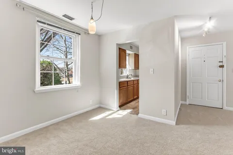 a view of an empty room with window and cabinet